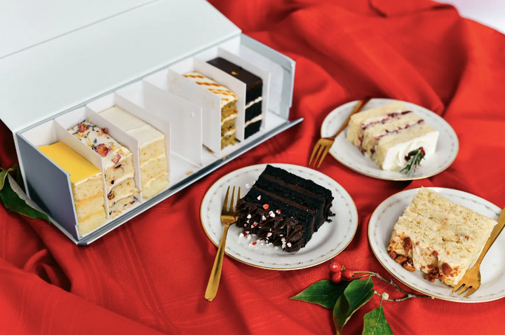 Eight rectangular slices of cake on a platter, each a different flavor.