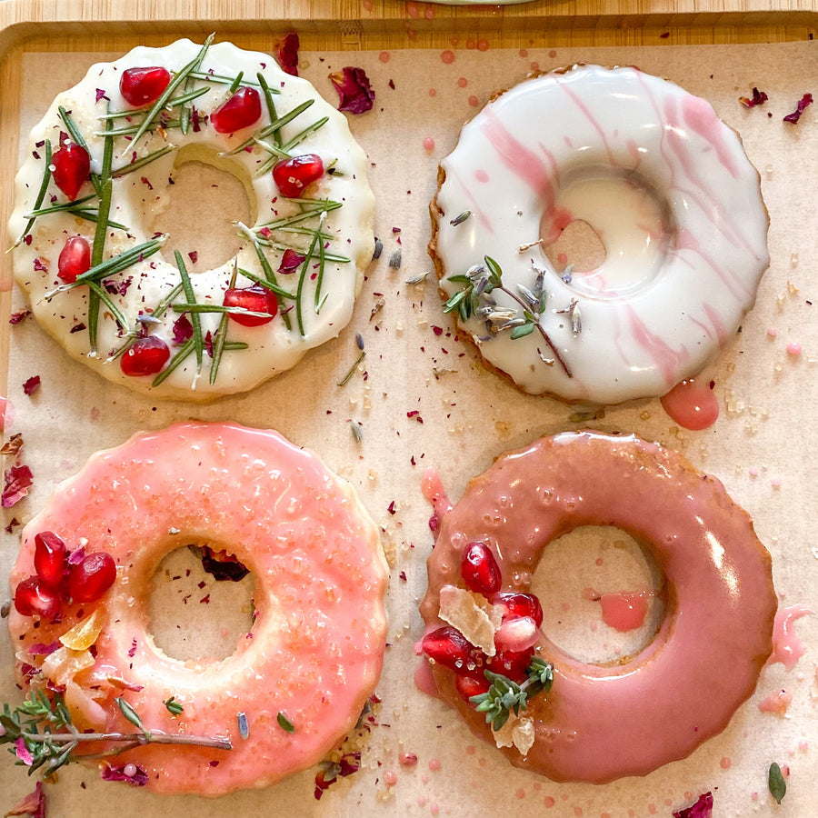Four wreath-shaped cookies decorated with colored glazes and pressed florals.