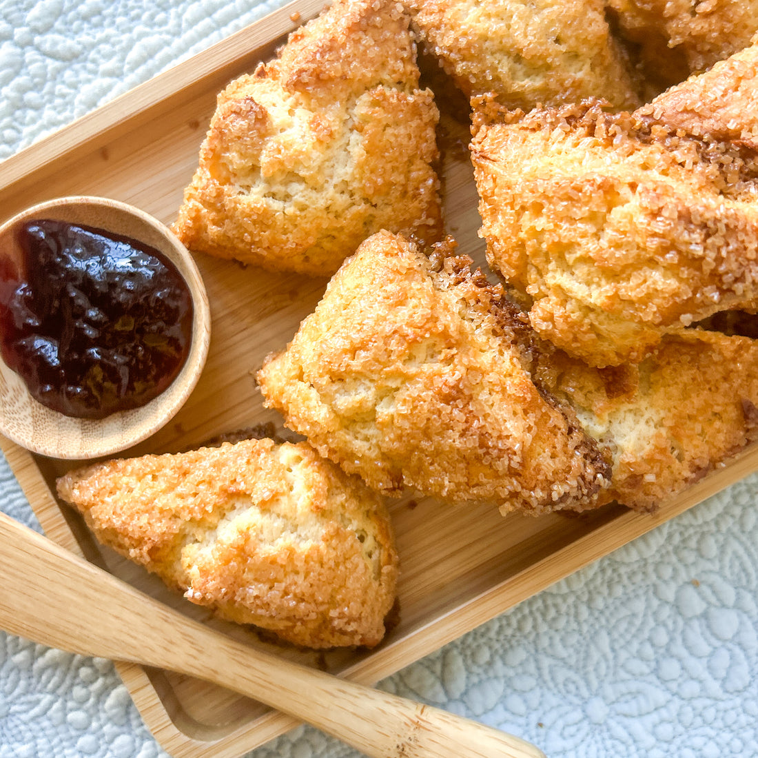 Scones on a wooden tray with a side of jam