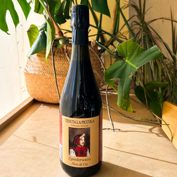 A bottle of red wine. The label reads: "Tenuta La Piccola. Lambrusco. Nero di Cio."