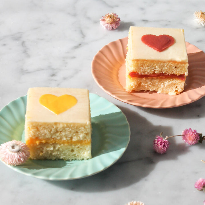 Two small square cakes decorated with hearts.