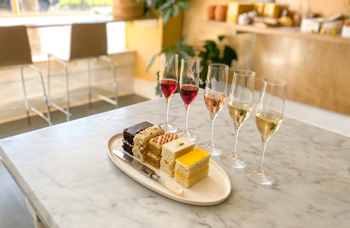 A plate with five slices of cake, each a different flavor, paired with a flight wine.