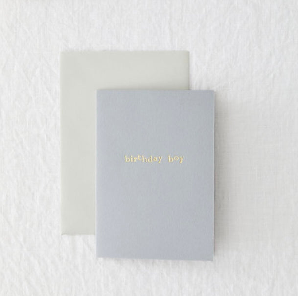 A light blue birthday card with "birthday boy" embossed in gold on the front.