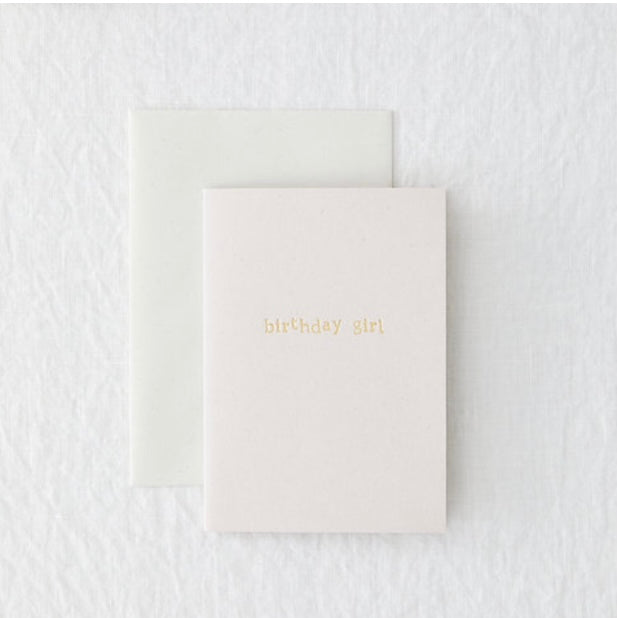 A light pink birthday card with "birthday girl" embossed in gold on the front.