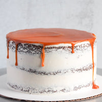 A chocolate beer cake covered in a sheer layer of white buttercream and topped with salted caramel.