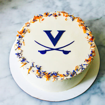 UVA graduation cake by Cake Bloom featuring a stenciled blue "V" and cavalier blue and orange edible flowers. Available for pick-up and local 