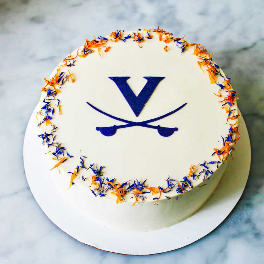 UVA graduation cake by Cake Bloom featuring a stenciled blue "V" and cavalier blue and orange edible flowers. Available for pick-up and local 