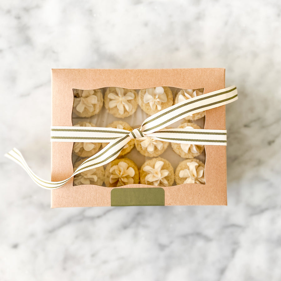 A gift box of bite-sized cakes, tied with a ribbon.