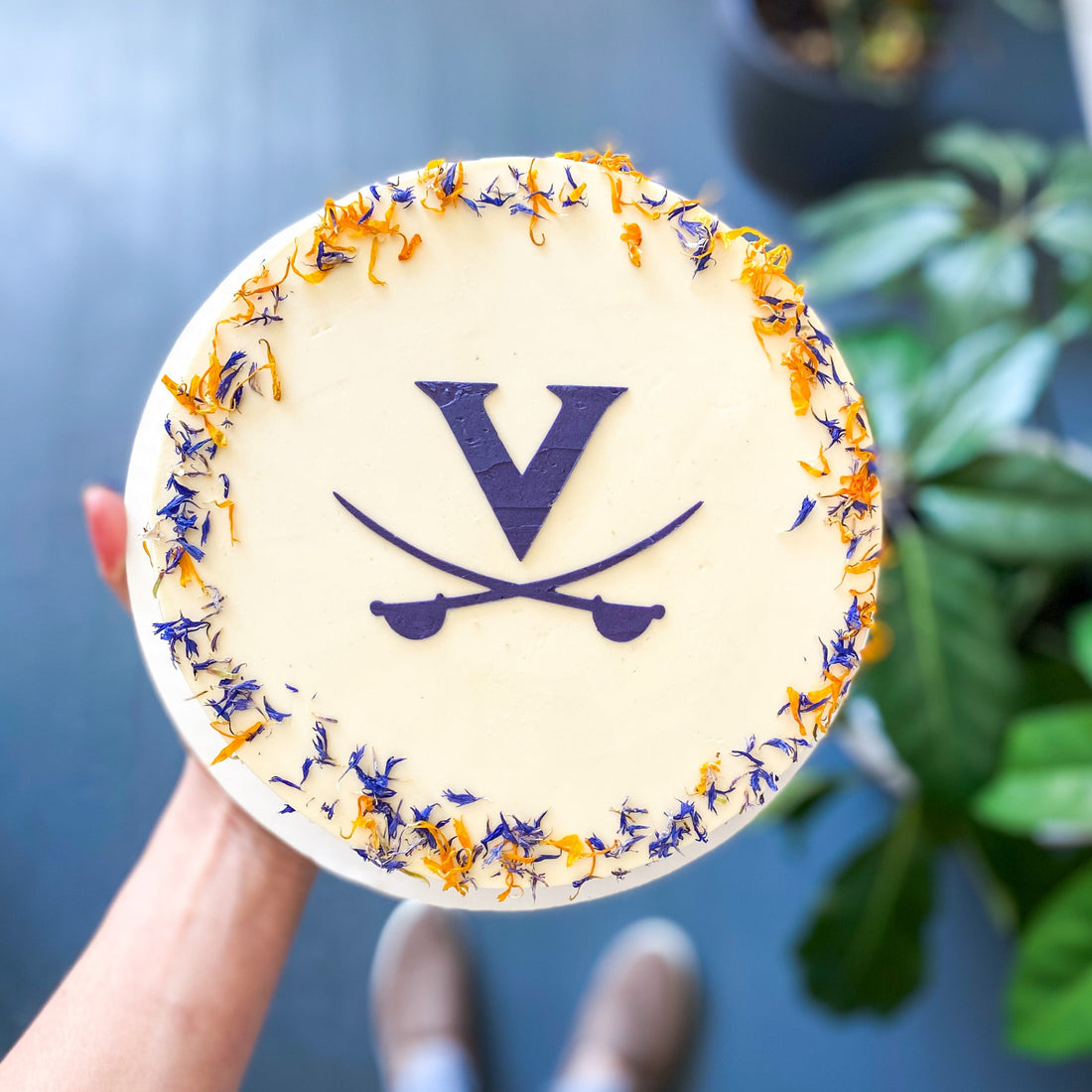 UVA graduation cake by Cake Bloom featuring a stenciled blue "V" and cavalier blue and orange edible flowers. Available for pick-up and local delivery in Charlottesville, Virginia.